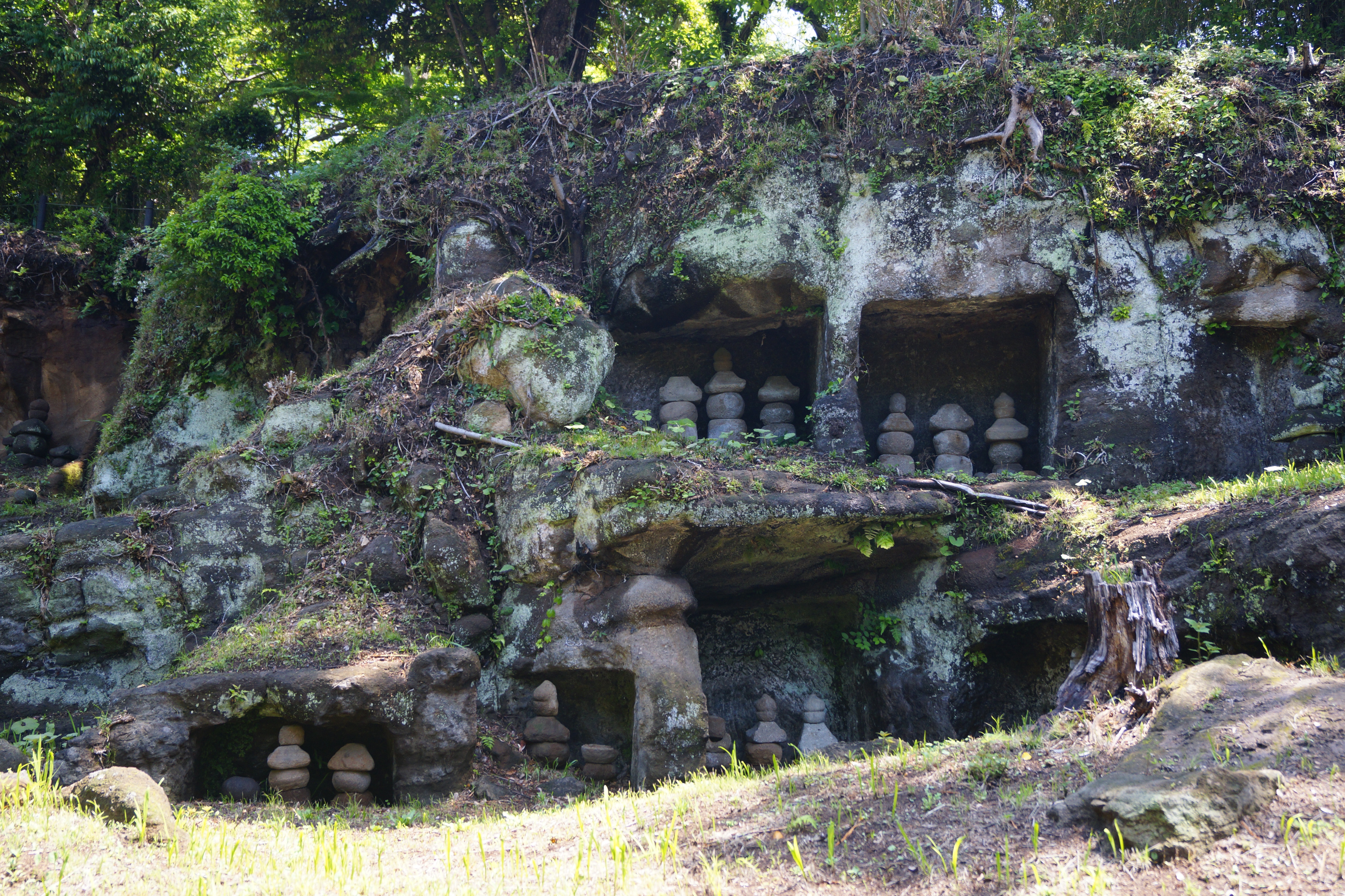 Steinmonumente in den Mandarado Yagura-Höhlen (takashikiji / Shutterstock.com)